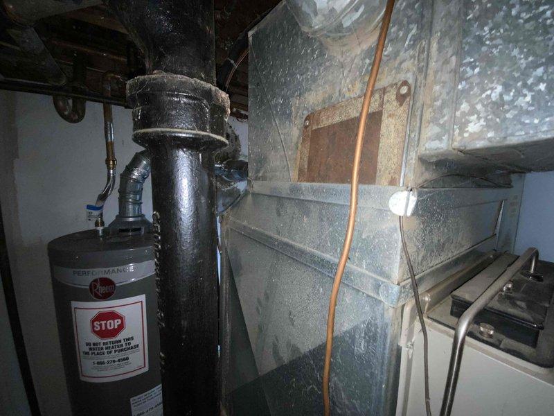 Conducted comprehensive assessment of existing 30-35 year old natural gas furnace and air conditioning system located in basement for equipment replacement estimate. Current HVAC system operational but nearing end of service life. Evaluated existing ductwork, ventilation components, and mechanical connections including gas lines, electrical supply, and condensate drainage systems. Documented equipment specifications, clearance requirements, and installation considerations for replacement units. Reviewed galvanized ductwork condition showing moisture accumulation and surface corrosion requiring attention during installation. Assessed utility connections and determined compatibility requirements for new high-efficiency equipment installation.