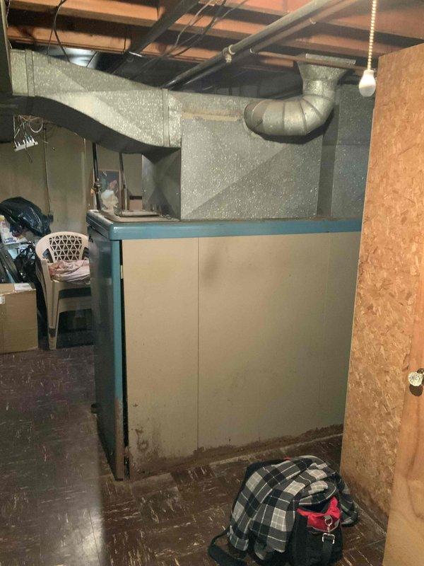 Conducted comprehensive assessment of 71-year-old Luxaire natural gas furnace located in basement utility area. Evaluated existing heating system configuration, ductwork connections, venting arrangement, and overall equipment condition to provide replacement estimate for aging HVAC equipment. Documented current installation including water heater proximity, copper piping layout, and available space requirements for new system installation.