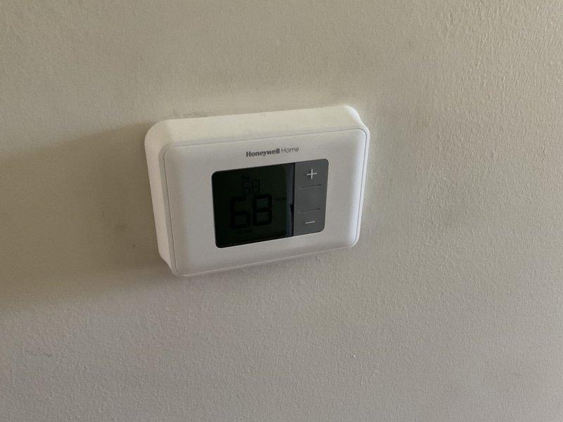 Completed comprehensive HVAC system estimate for full replacement of 20-year-old forced air heating and cooling system in ranch-style home with basement installation. Assessed existing natural gas furnace and outdoor air conditioning condenser unit currently positioned on concrete pad in residential patio area, along with existing Honeywell Home thermostat. Documented current system configuration and provided detailed replacement recommendations for complete HVAC system upgrade.