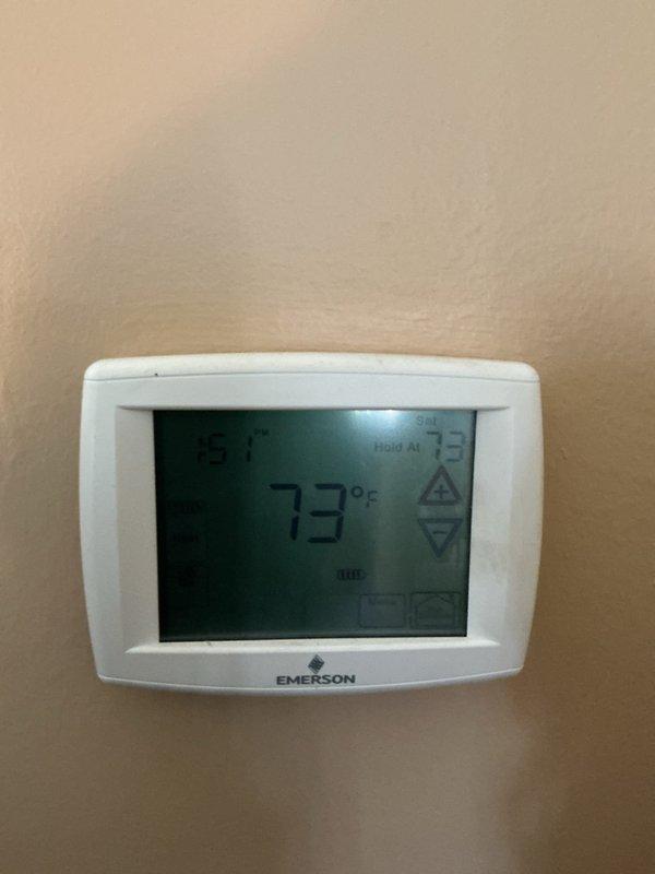 Completed annual cooling maintenance on residential HVAC system. Performed system diagnostics using clamp meter to verify electrical readings, tested capacitor functionality showing CD45+5X440R specifications within normal parameters, and confirmed thermostat operation displaying 73°F with 75°F setpoint. All components operating properly at time of inspection.