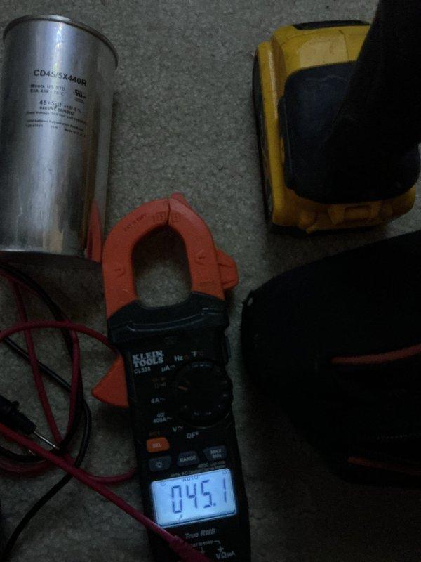 Completed annual cooling maintenance on residential HVAC system. Performed system diagnostics using clamp meter to verify electrical readings, tested capacitor functionality showing CD45+5X440R specifications within normal parameters, and confirmed thermostat operation displaying 73°F with 75°F setpoint. All components operating properly at time of inspection.