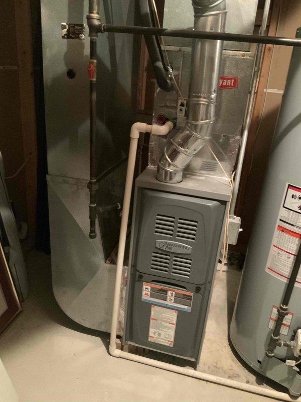 Completed furnace replacement estimate for residential property with existing gray furnace unit located in basement mechanical room. Assessed current HVAC system configuration including ductwork connections, PVC condensate drainage lines, and venting requirements for 8-10 SEER furnace replacement. Documented existing equipment layout, surrounding plumbing infrastructure, and available clearances for new installation to provide accurate replacement quotation.