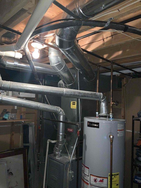 Completed furnace replacement estimate for residential property with existing gray furnace unit located in basement mechanical room. Assessed current HVAC system configuration including ductwork connections, PVC condensate drainage lines, and venting requirements for 8-10 SEER furnace replacement. Documented existing equipment layout, surrounding plumbing infrastructure, and available clearances for new installation to provide accurate replacement quotation.