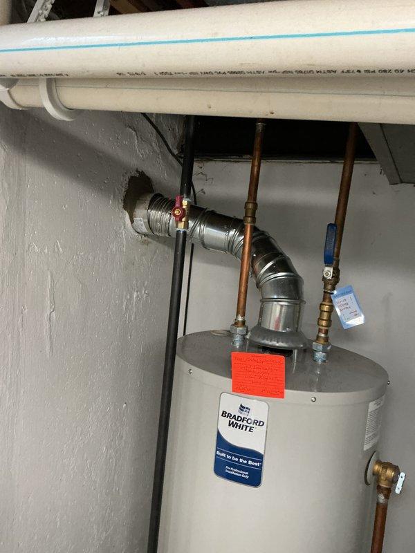 Completed callback for chimney liner installation on water heater system. Installed metallic B-vent ductwork with proper elbow joint configuration through wall penetration, ensuring secure connection from appliance flue collar to exterior termination point. Verified proper venting clearances, sealed all joints, and confirmed draft operation meets manufacturer specifications and local building codes.