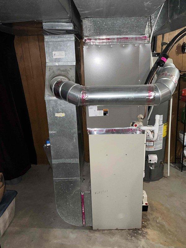 Conducted HVAC replacement estimate for 16-year-old furnace system located in basement utility area. Evaluated existing beige furnace unit with metallic ductwork, sheet metal plenum, and associated components including recent duct sealing work indicated by visible connection tape. Customer requested immediate replacement timeline following previous air conditioning installation completed in 2024.