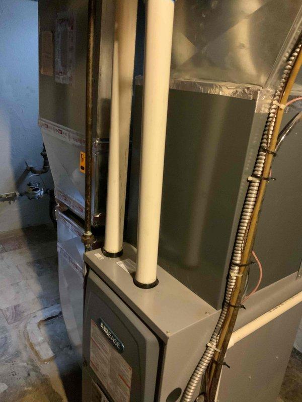 Completed full system estimate for forced air natural gas furnace and air conditioning replacement in basement of single-story bungalow residence. Assessed existing HVAC equipment configuration, including current furnace unit with dual PVC vent piping system and adjacent water heater placement. Evaluated electrical panel capacity and circuit availability for new equipment installation requirements. Documented existing ductwork layout with metallic foil insulation and flexible conduit routing. Photographed mechanical room conditions, equipment clearances, and utility connections to provide comprehensive proposal for complete HVAC system replacement under promotional equipment offer.