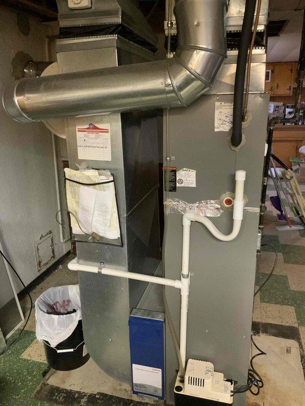Conducted comprehensive evaluation of 16-year-old residential air conditioning system experiencing refrigerant loss due to substantial leak, suspected to be located in evaporator coil. System utilizes R-22 refrigerant, which is obsolete and no longer manufactured. Documented existing outdoor condensing unit installation on exterior brick wall with proper electrical service and drainage. Assessed indoor furnace and air handler configuration in basement mechanical room, noting current ductwork, condensate drainage system, and overall HVAC infrastructure. Provided detailed estimate for complete air conditioning system replacement, excluding existing furnace, to address non-functional cooling system and upgrade to modern, environmentally-compliant refrigerant technology. Photographed current equipment placement and utility connections for replacement planning purposes.