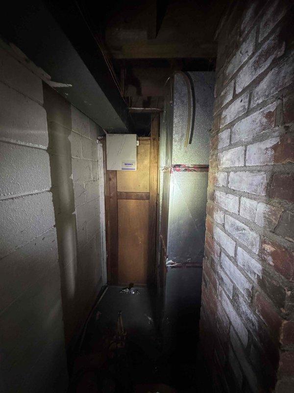 Conducted site assessment for new air conditioning system installation at residence with no existing AC unit. Evaluated basement utility area and mechanical room infrastructure, documenting existing HVAC infrastructure, electrical service access points, and available space for equipment placement. Photographed current conditions including water heater location, exposed brick and concrete block walls, ceiling clearances, and existing ductwork to determine optimal routing for new refrigerant lines and condensate drainage. Prepared comprehensive quote for complete air conditioning system installation including indoor air handler, outdoor condensing unit, refrigerant piping, electrical connections, and thermostat controls.
