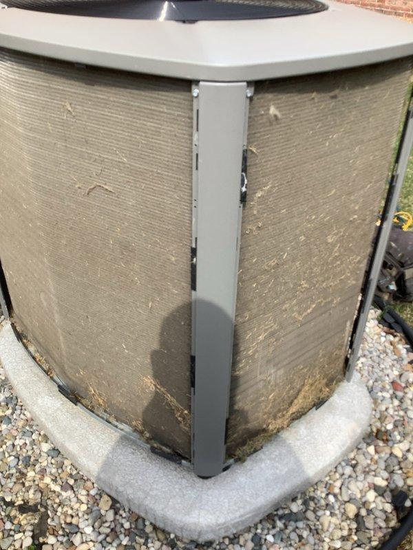 Completed scheduled maintenance on outdoor air handling condenser unit. Performed standard AHC maintenance protocol including inspection of exterior panels, coil surfaces, and mounting pad condition. Unit showed typical weathering and debris accumulation on exterior surfaces and coil fins from environmental exposure. Documented equipment condition with photos showing gravel bed installation, concrete pad, and protective mesh screening with age-appropriate wear patterns.