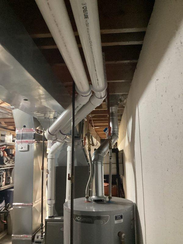 Completed full HVAC system installation including a 90,000 BTU furnace and 3-ton air conditioning unit with left-side configuration in basement utility area. Installed new ductwork connections, white PVC venting system with proper drainage routing, and integrated humidifier into the system. Reconnected all electrical and mechanical components, secured all piping with appropriate brackets and supports, and ensured proper clearances around water heater and existing utilities. All mechanical and electrical permits were obtained prior to installation, and system was tested for proper operation upon completion.