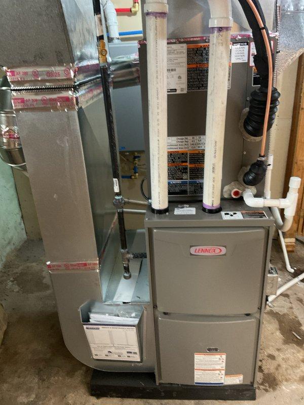 Completed full HVAC system installation including a Lennox 70,000 BTU furnace and 2.5 ton air conditioning unit with right-side placement configuration. Installed new electrical circuit to support system requirements, ran copper refrigerant lines with insulation, and configured white PVC intake and exhaust venting. Unit mounted on platform base with all ductwork connections completed, system tested and operational upon completion.