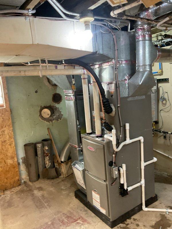 Completed full HVAC system installation including a Lennox 70,000 BTU furnace and 2.5 ton air conditioning unit with right-side placement configuration. Installed new electrical circuit to support system requirements, ran copper refrigerant lines with insulation, and configured white PVC intake and exhaust venting. Unit mounted on platform base with all ductwork connections completed, system tested and operational upon completion.