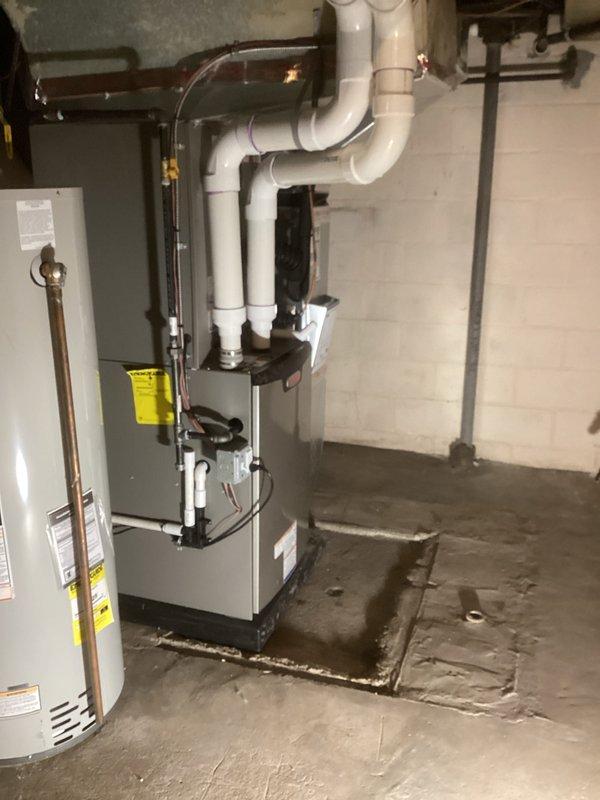 Completed full HVAC system installation including a 110,000 BTU furnace, 4-ton air conditioning unit with rear discharge configuration, whole-home humidifier, and hot water heater with liner in basement utility room. All copper refrigerant lines, PVC condensate drainage, gas connections, and electrical hookups were professionally installed and tested. System was fully commissioned with all equipment operational and permits obtained prior to installation.