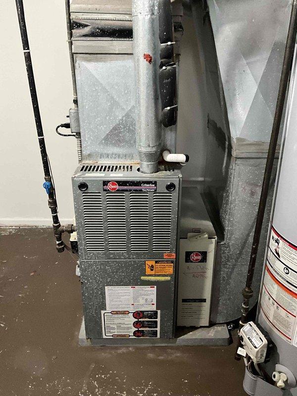 Conducted comprehensive assessment of existing 20+ year old Rheem Criterion furnace and complete HVAC system at rental property requiring immediate replacement. Documented current system configuration including furnace unit, galvanized ductwork network, gas line connections, and adjacent water heater in basement utility area. Accessed property using lockbox code and photographed all equipment for estimate preparation, noting system age and need for full replacement installation.