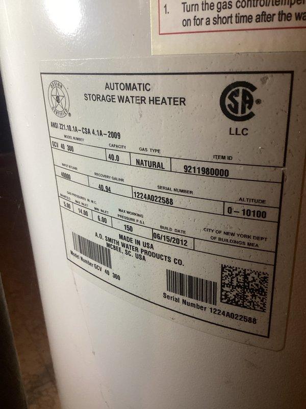 Responded to no hot water complaint in residential property. Upon inspection, found 40-gallon A.O. Smith natural gas water heater manufactured in 2012 with complete loss of hot water production. Unit showed 14 years of service life, exceeding typical 8-12 year lifespan for tanked water heaters. Evaluated gas supply line, shut-off valve, and copper piping connections for proper operation. Inspected manufacturer specification label confirming 40,300 BTU rating and 40-gallon capacity. Assessed condition of gas control valve, thermocouple, and burner assembly. Examined venting system and flue configuration for code compliance. Documented existing plumbing infrastructure including aged copper supply lines showing oxidation and patina consistent with original 1965 construction. Photographed unit specifications and surrounding plumbing connections for service records. Advised customer on water heater condition, age-related failure, and replacement options given unit's extended service beyond 