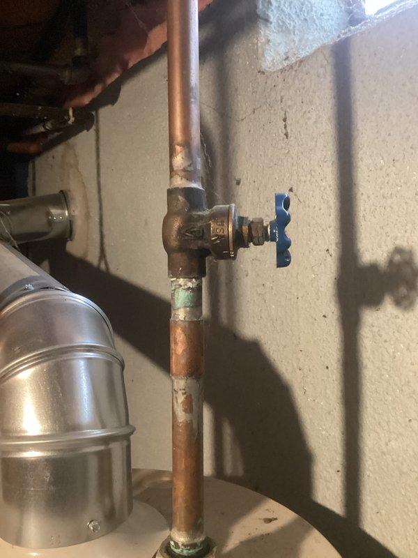 Responded to no hot water complaint in residential property. Upon inspection, found 40-gallon A.O. Smith natural gas water heater manufactured in 2012 with complete loss of hot water production. Unit showed 14 years of service life, exceeding typical 8-12 year lifespan for tanked water heaters. Evaluated gas supply line, shut-off valve, and copper piping connections for proper operation. Inspected manufacturer specification label confirming 40,300 BTU rating and 40-gallon capacity. Assessed condition of gas control valve, thermocouple, and burner assembly. Examined venting system and flue configuration for code compliance. Documented existing plumbing infrastructure including aged copper supply lines showing oxidation and patina consistent with original 1965 construction. Photographed unit specifications and surrounding plumbing connections for service records. Advised customer on water heater condition, age-related failure, and replacement options given unit's extended service beyond 