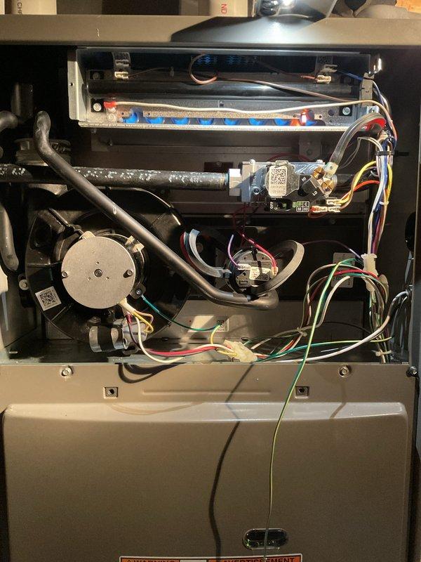 Performed comprehensive annual heating check on gas furnace system. Removed access panels and inspected all internal components including burner assembly with flame ports, draft inducer motor, blower motor assembly, heat exchanger, gas supply lines, and electrical control boards. Verified proper operation of all safety controls, ignition system, and flame sensors. Inspected wiring harnesses and electrical connections throughout unit for signs of wear or damage. Checked refrigerant lines and confirmed secure mounting of all mechanical components. Documented system condition with photographs showing burner assembly, control boards with QR identification labels, motor assemblies, and overall internal component layout. All components found to be in operational condition with no immediate repairs required.