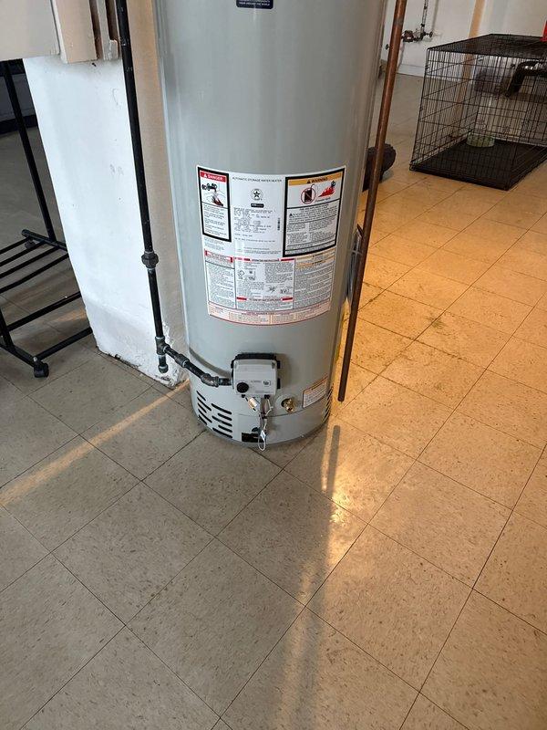 Successfully installed a 40-gallon tanked water heater in residential utility area. Installation included proper copper piping connections, shut-off valve with accessible red handle for emergency water control, and vented burner compartment assembly. Mechanical permit obtained and all work completed to code specifications.