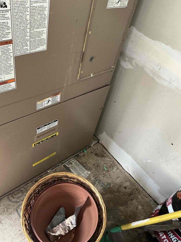 Conducted in-home estimate for complete HVAC system replacement in condo unit with 21-year-old air conditioning and furnace equipment. Assessed existing beige metal HVAC unit located in basement utility room, documented electrical panel configuration with multiple circuit breakers, and photographed current system condition including unit placement, surrounding work area, and electrical infrastructure. Provided homeowner with replacement options and specifications for new system installation.