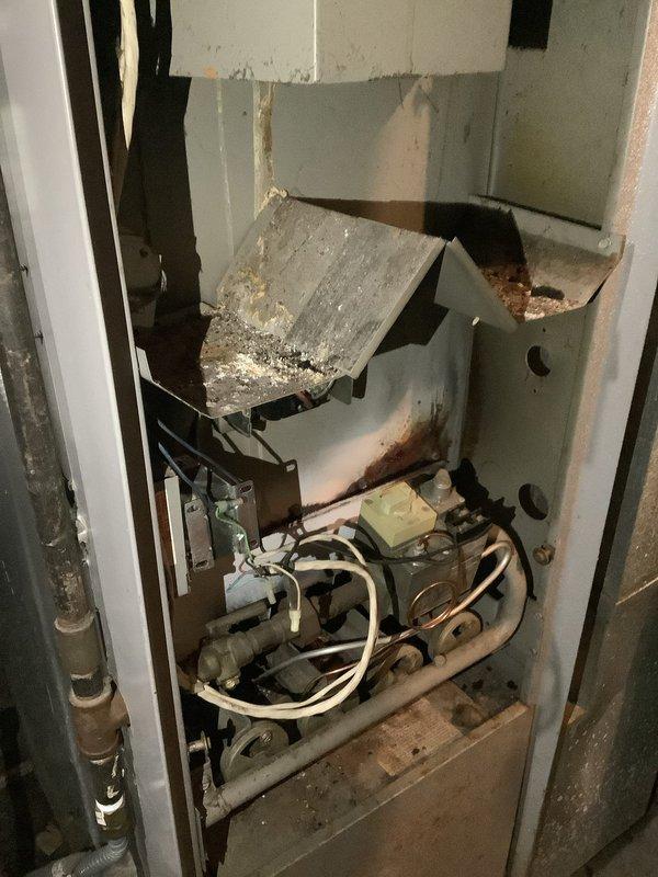 Responded to no-heat call on residential furnace system. Upon arrival, unit was completely non-operational with no error codes displayed on control board. Conducted thorough diagnostic inspection of furnace cabinet and discovered severely deteriorated and displaced insulation material within the unit, along with extensive rust staining on interior metal panels and components. The displaced insulation was protruding into the cabinet space and showed significant contamination and discoloration. Inspected all electrical connections, wiring harnesses, and control mechanisms for damage or interference from the compromised insulation material. Examined ductwork system including main supply plenum and condensate drain pan, noting accumulation of debris and general aging of system components. Documented existing conditions with photographs showing extent of internal cabinet deterioration, insulation failure, and overall system condition. Advised property owner that furnace cabinet integrity ha