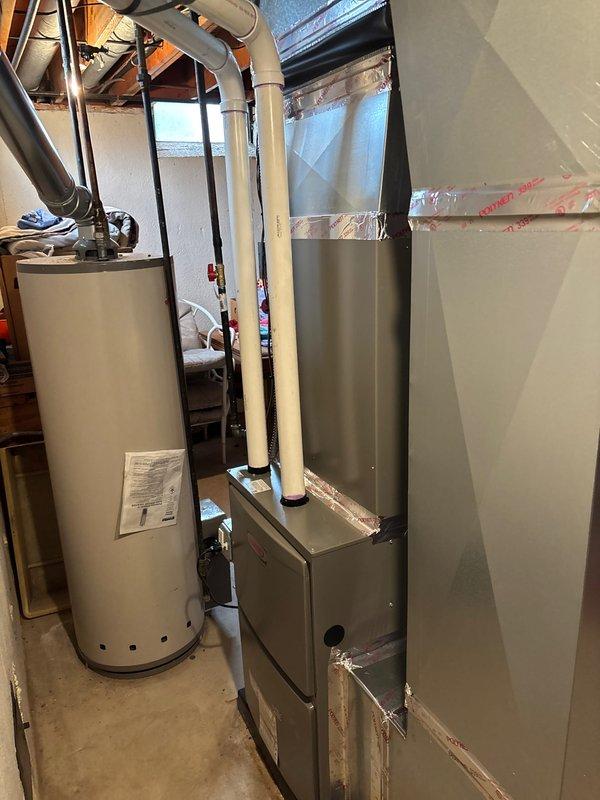 Completed full HVAC system installation including a 90,000 BTU furnace and air conditioning unit in basement mechanical room. Installed new ductwork with reflective insulation, reconnected all necessary piping and ventilation components, and installed fresh air filtration system with foam filter media. All equipment properly positioned, vented with white PVC exhaust piping, and integrated with existing water heater infrastructure, ensuring proper clearances and code-compliant installation throughout.