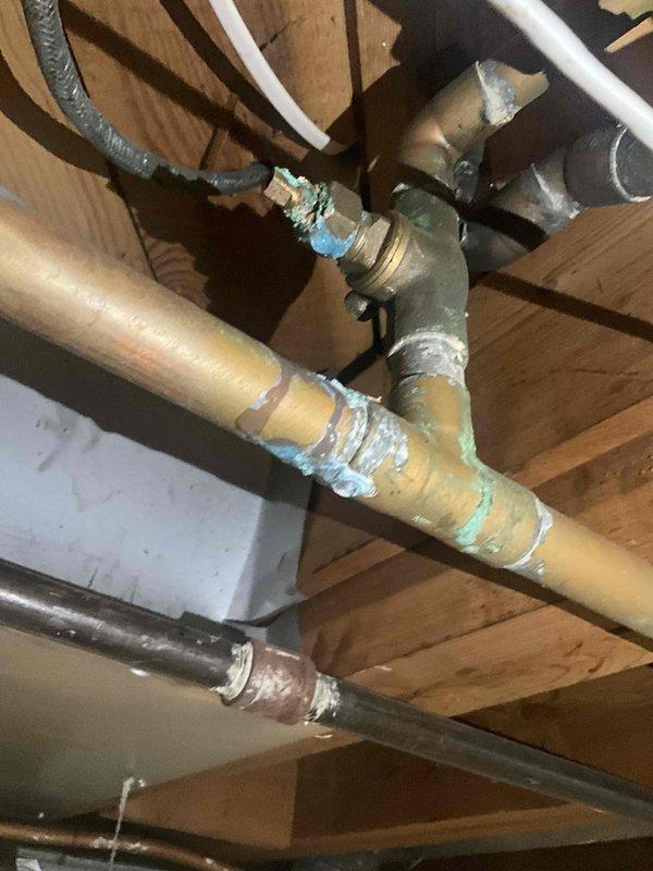 Conducted on-site assessment for standard water heater replacement in basement location. Evaluated existing 13-year-old unit currently in operational condition. Inspected electrical panel configuration and existing plumbing connections including copper supply lines, shutoff valves, and distribution piping. Documented infrastructure for standard water heater installation estimate, noting corroded fittings and aged connections at junction points beneath floor joists that will require attention during replacement.