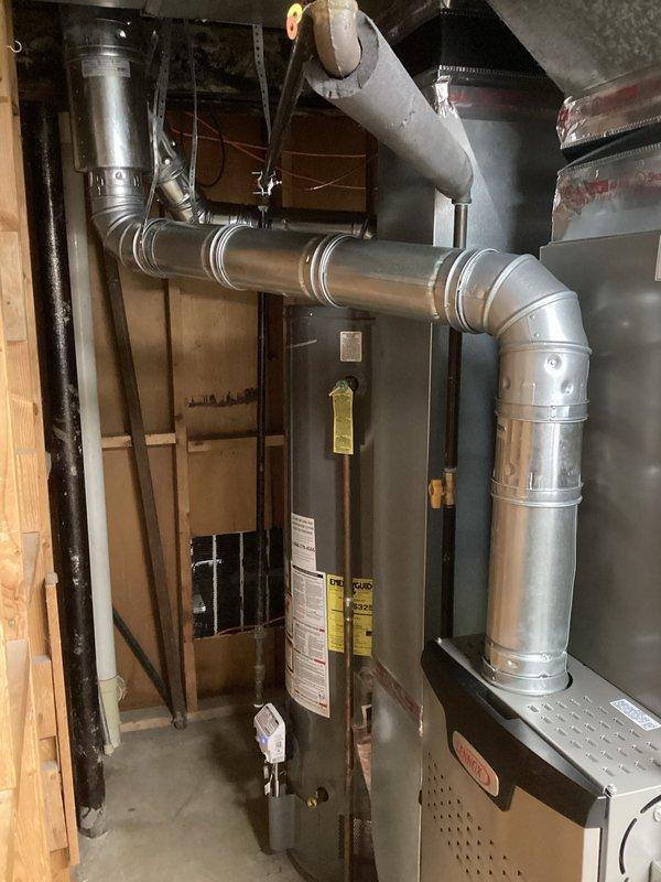 Completed full HVAC system installation including a 90,000 BTU furnace and 3-ton air conditioning unit with rear discharge configuration. Installed complete ductwork system with multiple 90-degree elbows and transitions to accommodate existing structural framing in basement utility area. Performed all necessary grounding and bonding connections, reconnected existing utilities, and secured all required mechanical and electrical permits for the installation.