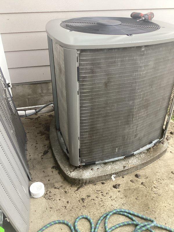# HVAC Annual Maintenance Completed

Performed comprehensive annual heating and cooling maintenance on residential split system. Inspected outdoor condenser unit and found heavy accumulation of dust, debris, and dark staining on evaporator coils and metal fins. Cleaned condenser coils thoroughly to restore proper airflow and heat transfer efficiency. Checked refrigerant lines and service valves; confirmed proper connections with valve caps intact. Verified condenser fan operation and inspected electrical components including wiring connections. Unit positioned on concrete pad with adequate clearance from building. Documented equipment condition with photos showing before cleaning status. System operational upon completion of maintenance service.