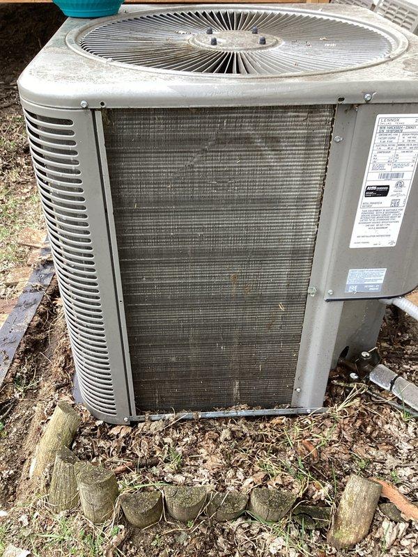 Completed annual cooling maintenance on residential air conditioning system. Performed visual inspection of outdoor condenser unit, noting significant accumulation of dirt, dust, and debris on heat exchanger coils requiring attention. Documented equipment condition and surrounding installation area showing outdoor weathering consistent with normal seasonal exposure.