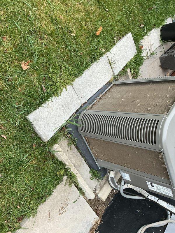 Completed annual cooling maintenance on residential split system HVAC unit. Inspected indoor evaporator coil assembly, noting moderate dust accumulation with visible discoloration on coil surface requiring monitoring for future cleaning. Verified blower compartment accessibility and checked flexible condensate drain line routing. Evaluated outdoor condensing unit positioned on concrete pad, inspecting finned coil condition and refrigerant line insulation integrity. Documented equipment condition through photographic records for maintenance history. All components operational at time of service completion.