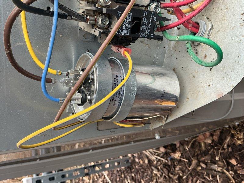 Completed scheduled air conditioning maintenance on residential split system unit. Inspected electrical components including capacitor and contactor, verified refrigerant line connections, and documented system operating on concrete pad with proper grounding in place.