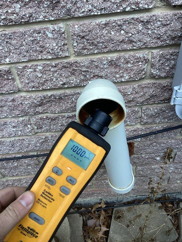 Responded to customer report of gas odor from furnace exhaust on 19-year-old unit located in basement. Upon inspection, measured carbon monoxide levels at exterior PVC exhaust termination point, which registered 1080 PPM—significantly above safe levels. This elevated reading indicates incomplete combustion within the furnace heat exchanger, likely due to age-related deterioration or cracking, allowing combustion gases to mix improperly before venting, creating both a safety hazard and the reported gas smell.