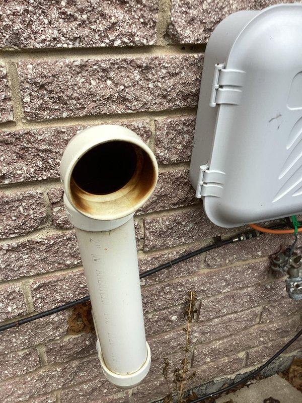 Responded to customer report of gas odor from furnace exhaust on 19-year-old unit located in basement. Upon inspection, measured carbon monoxide levels at exterior PVC exhaust termination point, which registered 1080 PPM—significantly above safe levels. This elevated reading indicates incomplete combustion within the furnace heat exchanger, likely due to age-related deterioration or cracking, allowing combustion gases to mix improperly before venting, creating both a safety hazard and the reported gas smell.