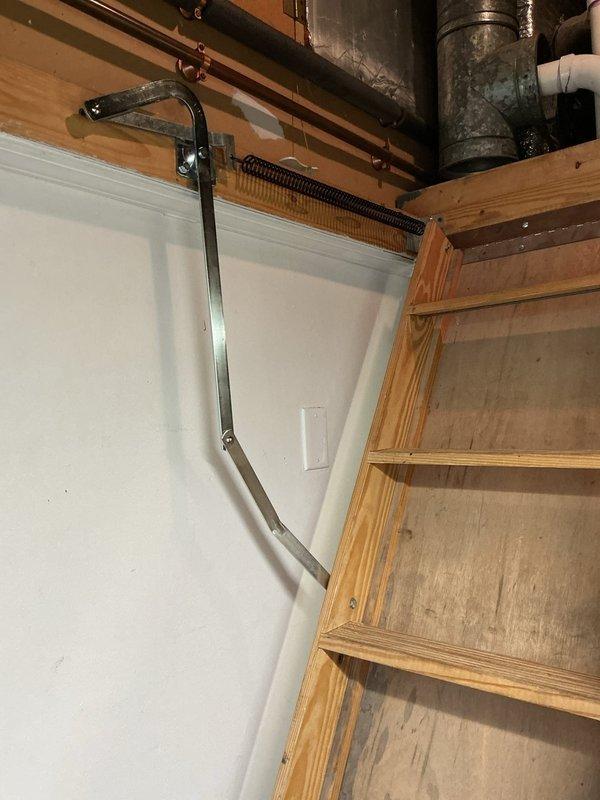 Responded to callback regarding attic access door malfunction following recent furnace and air conditioning system installation. Attic door was not closing properly due to misaligned or damaged spring-loaded arms on the pull-down ladder assembly. Replaced defective arms on attic door hardware to restore proper operation and ensure secure closure of access point.