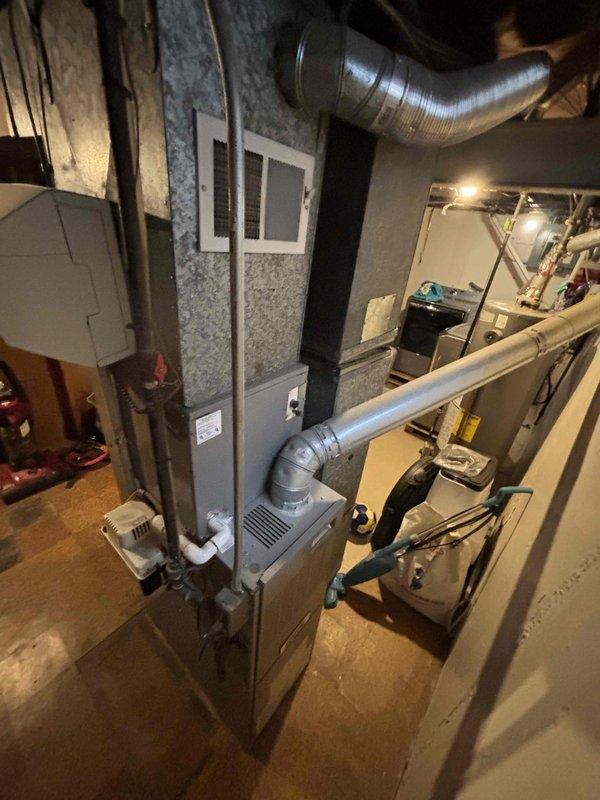 Provided estimate for replacement of 28-year-old furnace and air conditioning system located in basement mechanical room. Current natural gas furnace with existing humidifier and ductwork system assessed for equipment upgrade recommendations. Documented existing HVAC installation including furnace unit, air handler, humidifier, condensate pump, and ductwork configuration to determine proper replacement specifications.