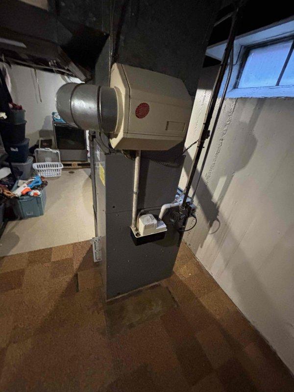 Provided estimate for replacement of 28-year-old furnace and air conditioning system located in basement mechanical room. Current natural gas furnace with existing humidifier and ductwork system assessed for equipment upgrade recommendations. Documented existing HVAC installation including furnace unit, air handler, humidifier, condensate pump, and ductwork configuration to determine proper replacement specifications.