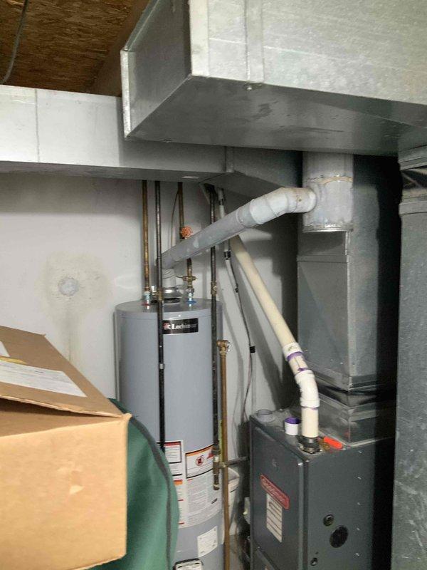 Assessed 19-year-old Goodman furnace system with failed heat exchanger in basement mechanical room. Documented existing equipment configuration including furnace, water heater, ductwork, and venting system. Provided comprehensive full system replacement estimate for new HVAC equipment due to heat exchanger failure requiring immediate replacement.