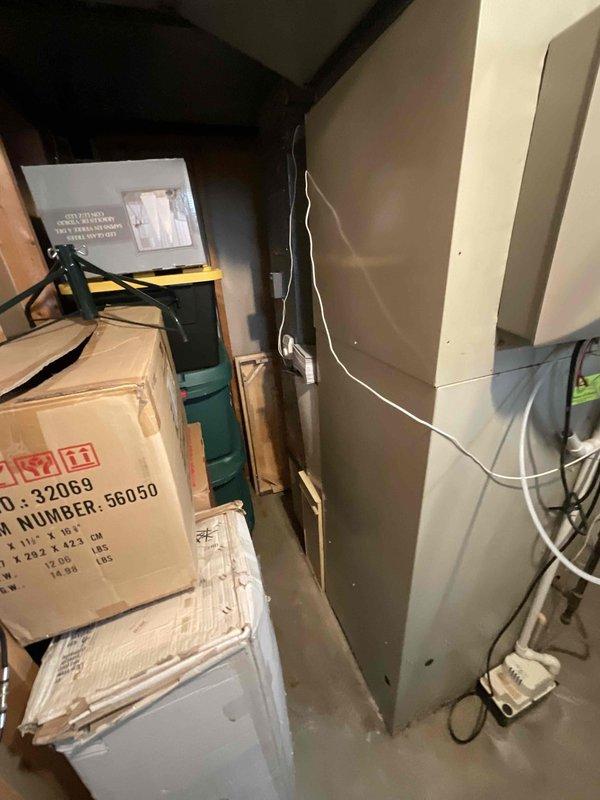 Conducted on-site assessment for complete HVAC system replacement in residential basement installation. Evaluated existing furnace and air conditioning equipment of unknown age for replacement specifications. Documented current equipment configuration including beige metal cabinet furnace unit with electrical conduit, water heater with dual exhaust venting, and existing ductwork infrastructure. Photographed mechanical room layout, utility clearances, and electrical connections to determine replacement equipment sizing and installation requirements. Prepared comprehensive replacement quote for new furnace and AC system with expedited installation timeline per homeowner request.
