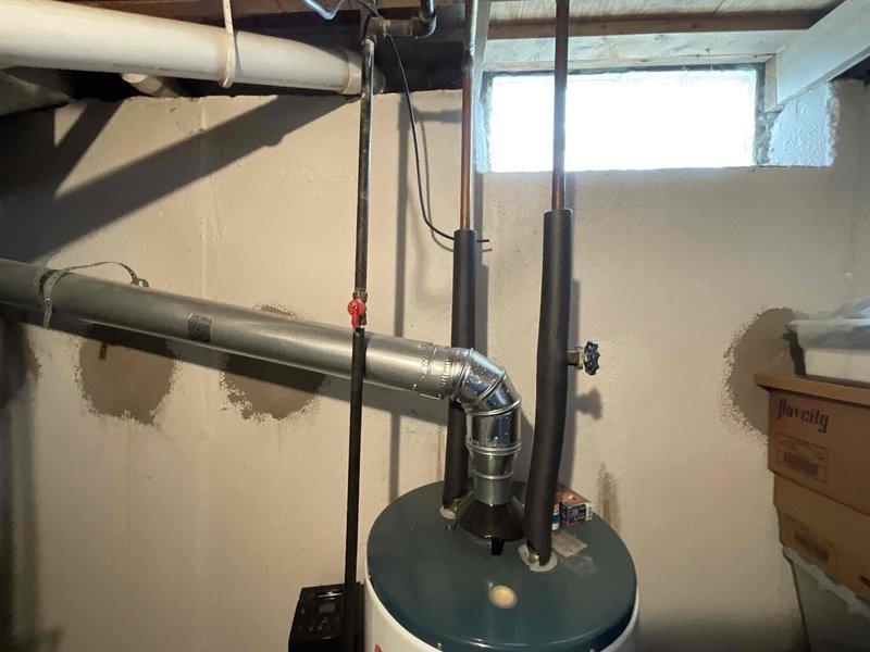 Conducted on-site assessment for complete HVAC system replacement in residential basement installation. Evaluated existing furnace and air conditioning equipment of unknown age for replacement specifications. Documented current equipment configuration including beige metal cabinet furnace unit with electrical conduit, water heater with dual exhaust venting, and existing ductwork infrastructure. Photographed mechanical room layout, utility clearances, and electrical connections to determine replacement equipment sizing and installation requirements. Prepared comprehensive replacement quote for new furnace and AC system with expedited installation timeline per homeowner request.