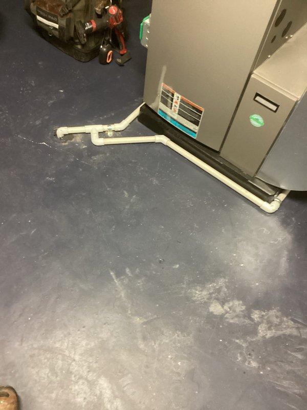 Completed installation of tankless water heater unit in utility room per permit specifications. Installed gray tankless unit with proper venting, established PVC condensate drain line routing with appropriate joints and elbows, and reconnected all necessary plumbing connections. Unit tested and operational with control panel indicators functioning properly.