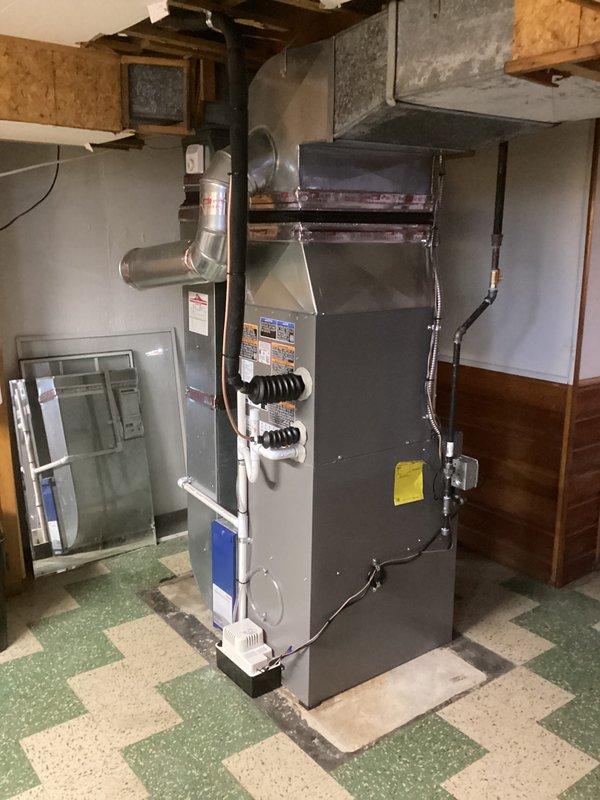 Completed full HVAC system installation including a 70,000 BTU furnace and 2-ton air conditioning unit with left-side configuration. Installed furnace in basement location on concrete block base with proper ductwork connections, ran electrical conduit and exterior refrigerant lines along brick exterior wall to outdoor condensing unit, and reconnected all necessary utilities. All mechanical permits obtained and installation performed to code specifications with system tested and operational upon completion.