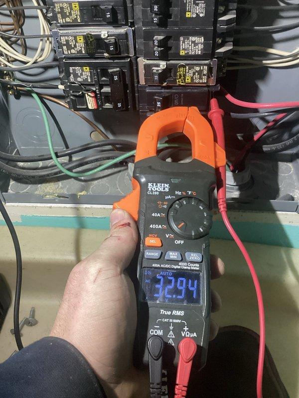 Responded to no cooling call with fan not operating. Upon arrival, performed electrical diagnostics at the breaker panel using digital clamp meter to measure voltage and amperage. Readings indicated abnormal electrical values at the main panel, with measurements showing 1183 and 2294 on the meter display during testing. Inspected circuit breakers, wiring connections, and power supply to the AC unit. Identified electrical supply issue affecting unit operation. Documented findings with photos of electrical measurements at the panel for reference and further evaluation of power delivery to the system.