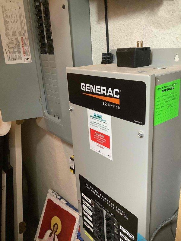 Completed on-site evaluation for installation of natural gas quick connect for portable generator at residential property. Assessed existing electrical infrastructure including Generac EZ Switch transfer switch system and main electrical panel. Documented current generator hookup configuration and exterior access point location on red brick structure. Photographed existing transfer switch installation and electrical panel to determine compatibility requirements for proposed natural gas quick connect addition. Evaluated exterior mounting location and gas line routing options for safe and code-compliant portable generator connection point.