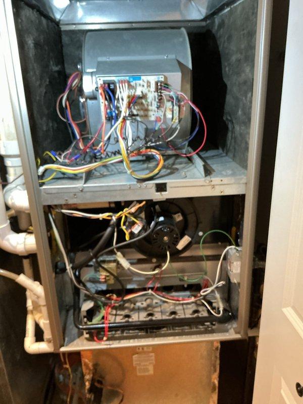 Responded to no cooling complaint on 10-15 year old central air conditioning system located in utility closet on main floor. Upon inspection, verified unit was running but not producing cool air. Examined condensate drain system and safety overflow switch as indicated by equipment labels. Inspected internal furnace components, blower assembly, and electrical connections. Documented equipment condition including manufacturer specifications, wiring configuration, and condensate management system with Asurity/Diversitech safety switch installed.