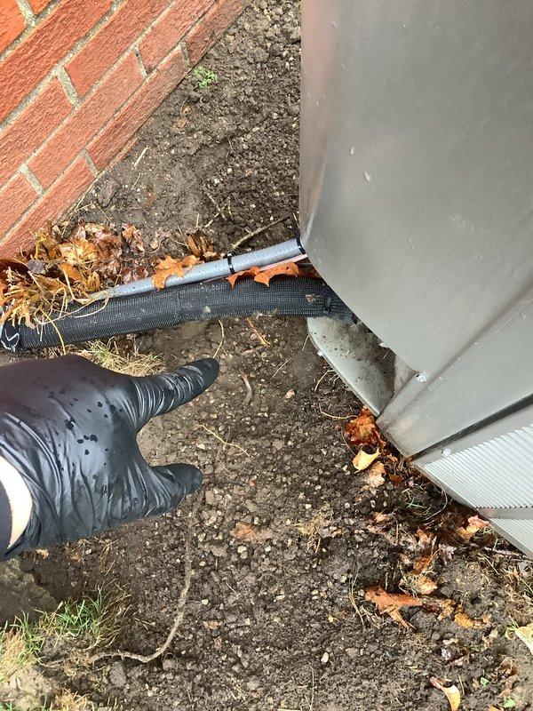 Responded to callback for generator grounding system inspection. Excavated soil around building foundation to expose ground rods and verify electrical connections. Relocated generator unit to access grounding components, tightened lock nut on ground rod connector, and confirmed proper weatherproof seal was installed on the connection point to prevent moisture intrusion and ensure code-compliant grounding integrity.