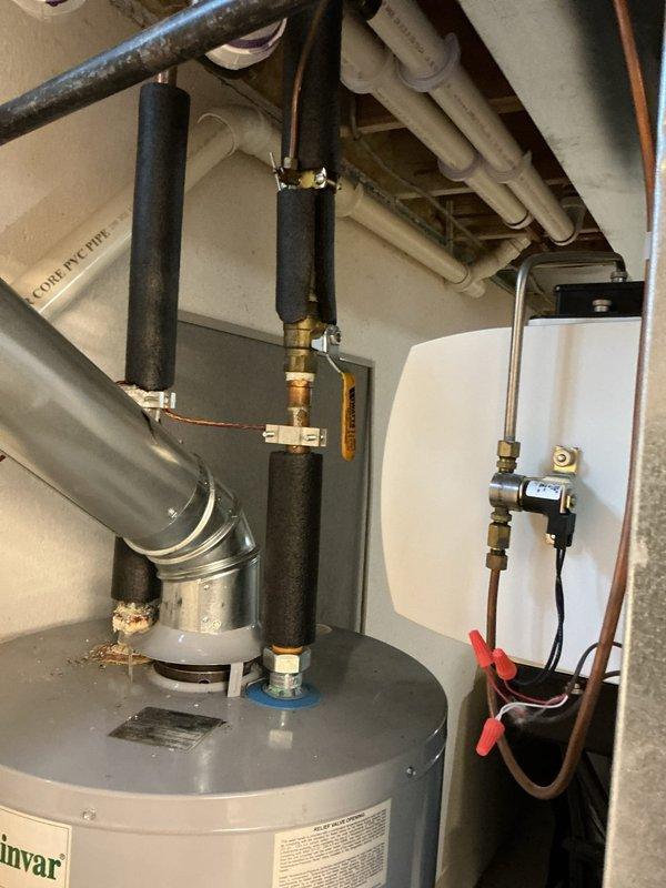 Completed annual HVAC maintenance on residential air conditioning system. Inspected indoor mechanical room components including water heater connections, refrigerant lines with foam insulation, and associated ductwork; verified proper operation of heating system components and electrical connections. Performed exterior inspection of ground-level ventilation grate and surrounding drainage systems; confirmed adequate airflow and cleared debris from ventilation openings.