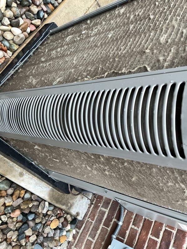 Completed annual HVAC maintenance on residential air conditioning system. Inspected indoor mechanical room components including water heater connections, refrigerant lines with foam insulation, and associated ductwork; verified proper operation of heating system components and electrical connections. Performed exterior inspection of ground-level ventilation grate and surrounding drainage systems; confirmed adequate airflow and cleared debris from ventilation openings.