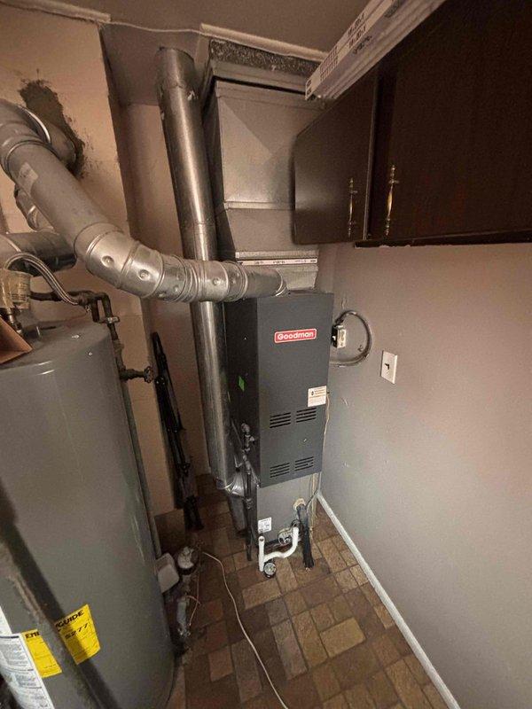 Provided estimate for replacement of 10-year-old Goodman natural gas furnace located in maintenance room. Current unit operational but customer seeking upgrade options. Evaluated existing installation including ductwork clearances, utility connections, and spatial requirements for new equipment installation in basement mechanical room alongside water heater.
