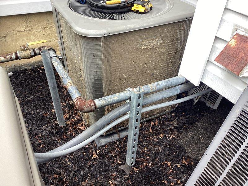 Completed annual AC tune-up on outdoor condensing unit. Performed comprehensive maintenance including inspection of refrigerant lines, electrical connections, and condenser coil cleaning. Unit operational and running within manufacturer specifications; documented existing weathering on insulation and minor surface corrosion on pipe fittings for future monitoring.