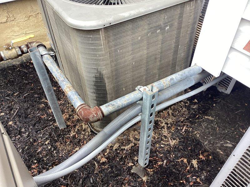 Completed annual AC tune-up on outdoor condensing unit. Performed comprehensive maintenance including inspection of refrigerant lines, electrical connections, and condenser coil cleaning. Unit operational and running within manufacturer specifications; documented existing weathering on insulation and minor surface corrosion on pipe fittings for future monitoring.